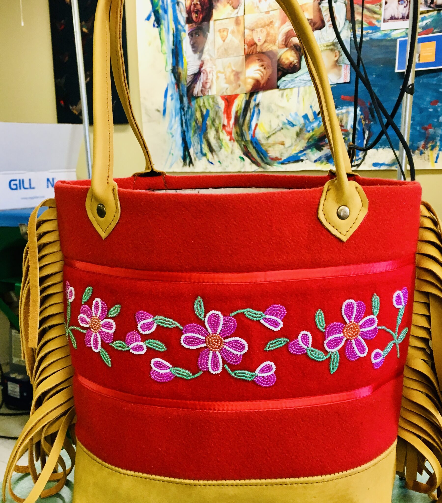 Red felt tote with three beaded roses, tan leather straps and fringe.