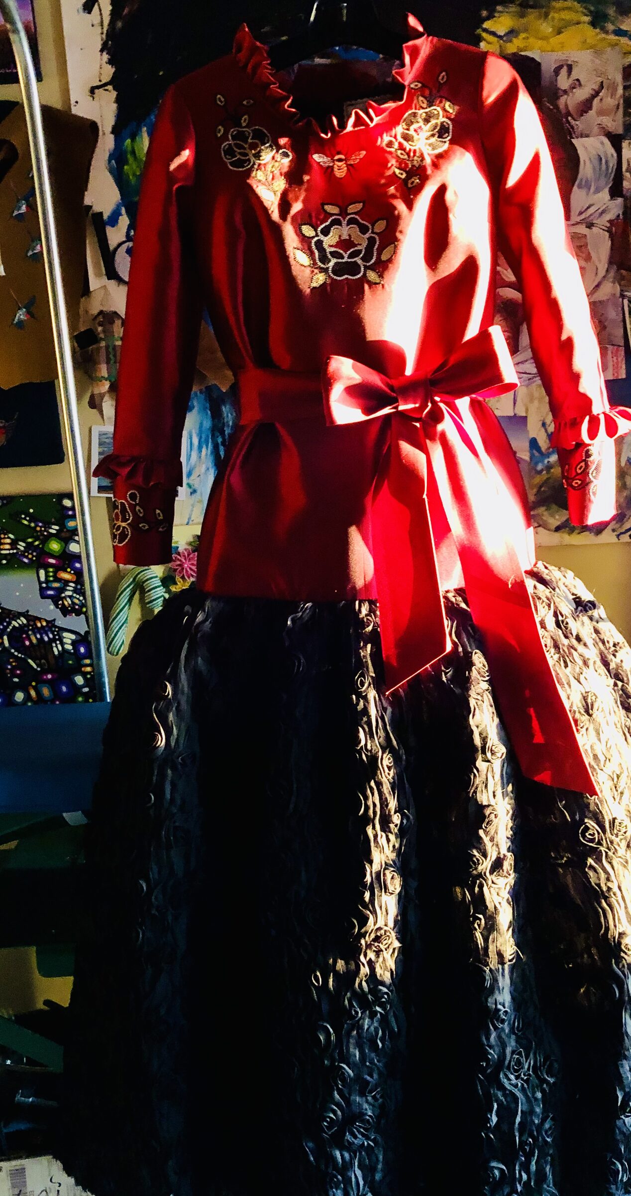 Red satin blouse with embroidery and a bow, on a form in the studio