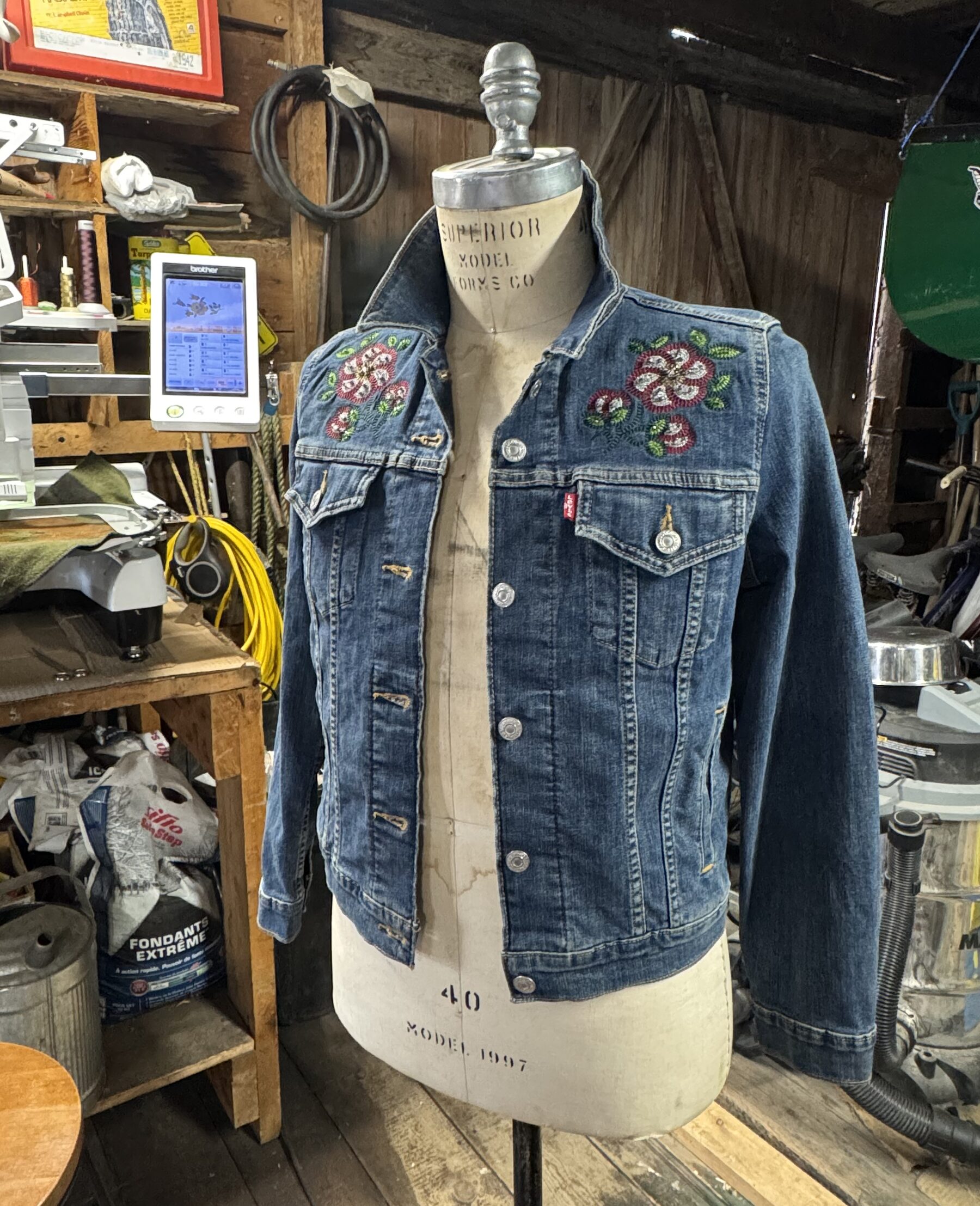 Blue denim jacket with crystal floral embroidery on a dress form
