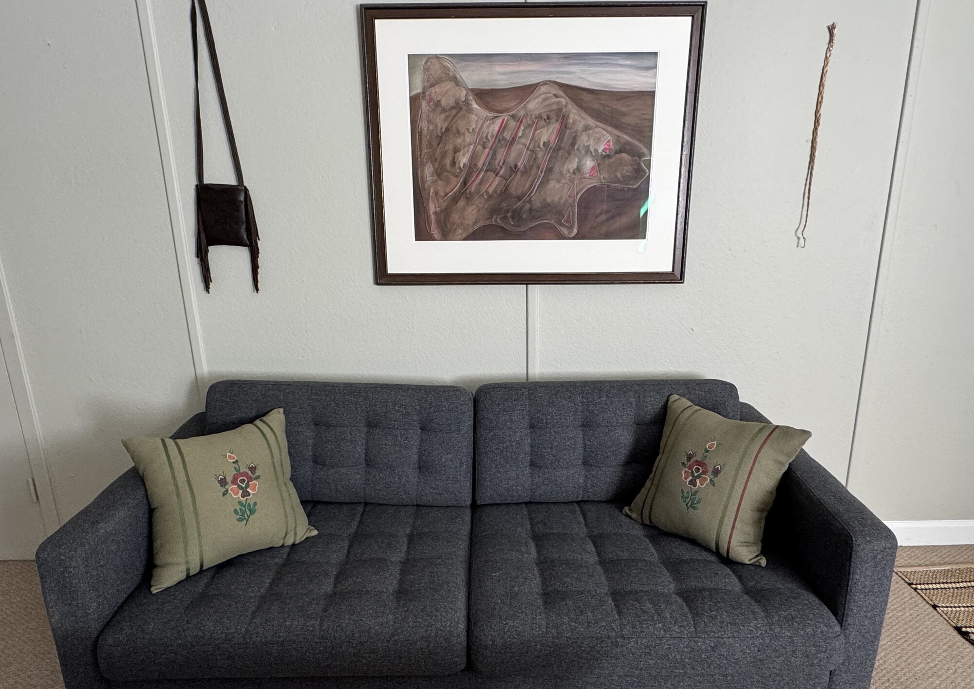 Sage embroidered pillows on a sofa