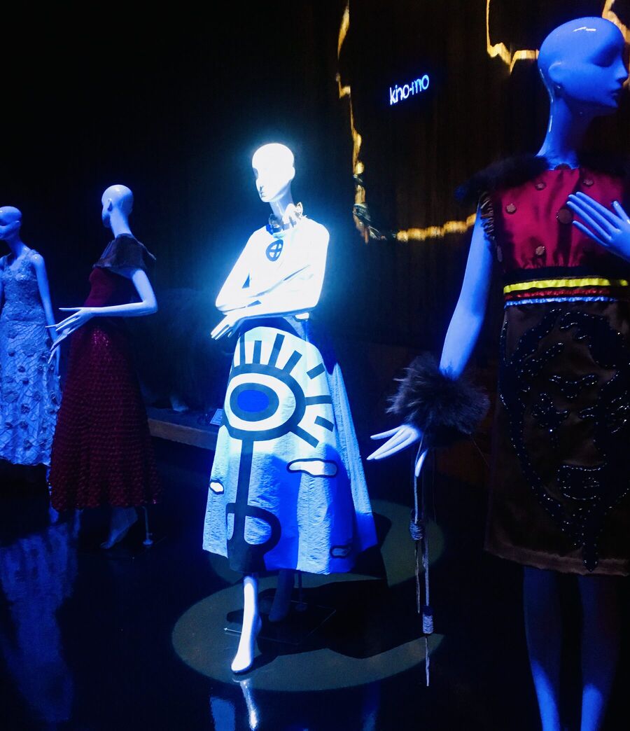 Gowns on mannequins in a dark exhibition hall